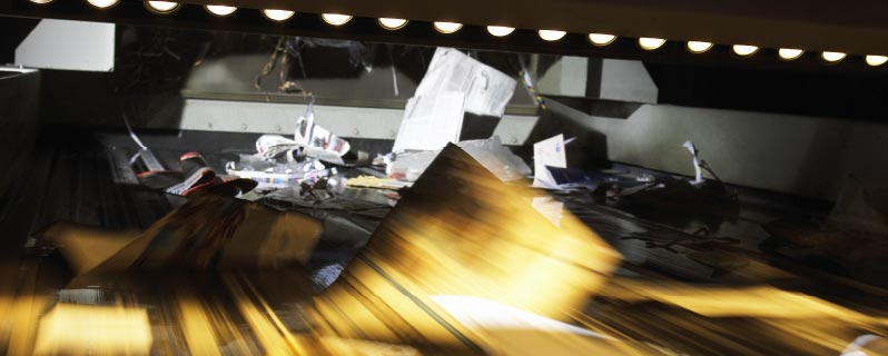 Altpapier auf dem Förderband einer Recycling-Anlage
