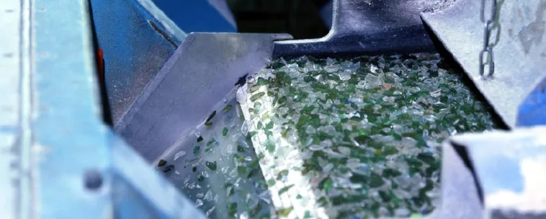 Förderband in der Recycling-Anlage mit zu winzigen Scherben zerbrochenem Glas